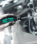 Hand using Kraftform Plus Slotted Screwdriver With One Eighth Inch Shaft And Two And Three Eighths Inch Blade Length for mechanics.