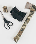 Self Cling Camouflage Fabric Wrap For Gear And Knives, Reusable And Washable, 2 Pack, shown with scissors and axe