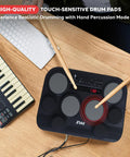 Compact Tabletop Electronic Drum Pad Kit With 8 Touch Sensitive Pads And Pedals on wooden desk with keyboard and sticks.