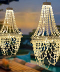 Give Your Outdoor Patio A Major Glow Up With This Stunning Handcrafted Solar Crystal Chandelier Featuring Cascading Diamond Sparkles And Weather Proof White Metal Frame, showcasing illuminated crystal strands.