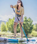 Person paddleboarding while wearing USCG Approved Manual Inflatable Belt Pack with Low Profile and 52 Inch Waist Fit.