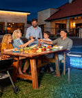 Family gathering outdoors with a table set for dinner, a grill, and an Outdoor Bug Zapper With Projector Lights