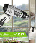 Using hot air gun with adjustable temperature for paint removal, showing heat output on window frame with gloves, max 1202°F.