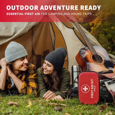 Front view of red AL21 first aid kit with white cross beside a guitar near a camping tent