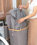 Breathable Fabric Laundry Hamper With Lid, Bamboo Frame, Side Handles, 26 Gallon Gray Go-To Laundry Basket in use in laundry room