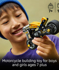 Child holding Technic Yellow Motorcycle Building Kit for Kids 7 and Up with Realistic 3 Piston Engine and a Working Rear Wheel 42225.