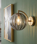 Mid‑Century Modern Globe Glass Wall Sconce with Wine Red Hand‑Blown Glass mounted on green wall, featuring ribbed glass shade.