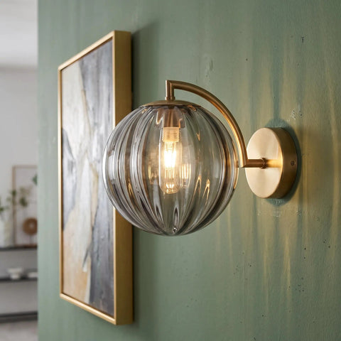 Mid‑Century Modern Globe Glass Wall Sconce with Wine Red Hand‑Blown Glass mounted on green wall, featuring ribbed glass shade.