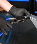 Midwest Seamer Tong, 3-inch offset sheet metal bender, shown in use with gloved hands and blue air hose.