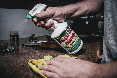 Hand holding Heavy Duty Cleaner Degreaser And Disinfectant All In One For Kitchens Bathrooms Tools Engines Vinyl 32 oz spray bottle