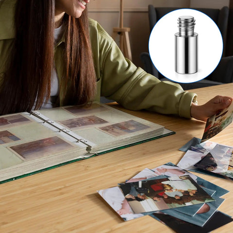 A person examining photos next to a scrapbook using Heavy Duty 20 Piece Scrapbook Extension Posts And Bookbinding Screws Rust Proof Copper 12 Millimeter Spacer Rings For Plug And Play Photo Album Refills No Fuss Craft Supply Kit.