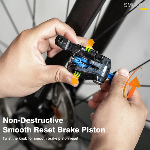 Hands using Bicycle Hydraulic Brake Caliper Spreader Tool for Mountain and Road Bikes on a disc brake.