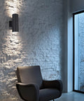 Indoor setting with Dusk To Dawn Outdoor Wall Light With Sensor ETL Listed Aluminum Up Down Cylinder Sconce illuminating a chair.