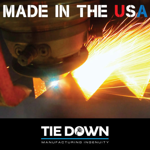 Welding sparks flying as metal is cut, with 'Made in the USA' text and Tie Down manufacturing logo visible in image.