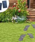 Feet-shaped stepping stone mold pair on a grassy garden with flowers, size 18x11 ft, reusable durable plastic for concrete DIY paths.