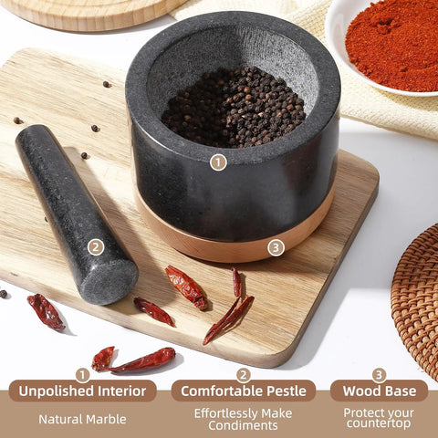 Black Mortar And Pestle Set With Wood Base Granite Grinder Bowls For Guac And Salsa Polished Non Scratch Avocado Bowl For Cooking Spices And Seasoning Kitchen Accessories. Mortar bowl filled with peppercorns and chili peppers nearby on wooden board.