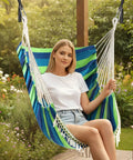 Hammock Chair Swing With Cushions Included Cozy And Chill, Easy Hanging With Strong Webbing Straps And Hooks, Soft Cotton Hanging Chair With Side Pocket And Tassel, Indoor Outdoor Relaxation For Ultimate Comfort In Blue Green showing woman relaxing.