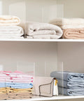 Clear Acrylic Shelf Dividers For Closet Organization 6 Pack Adjustable Book And Sweater Supports Straight Up Solid Zero Assembly Purse Separators neatly organizing stacked blankets and bags.