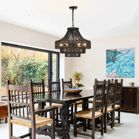 Hand Woven Black Rattan Plug In Pendant Light With Adjustable Chain in dining room above wooden table and chairs.