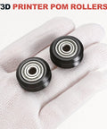 POM V Slot Pulley Wheels Set With 625zz Bearings For Slick High Speed Gantry Motion In DIY 3D Printers And CNC Machines 24mm OD 5mm ID 6mm Wide Black Finish, two black wheels on gloved hand