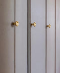 Top Shelf Unlacquered Brass Cabinet Knobs Straight Up Modern Round Dish Hardware Featuring Live Patina Finish 1.18 Inch Face Width For A Cool Kitchen Revamp Two Pack Bundle on white cabinets.