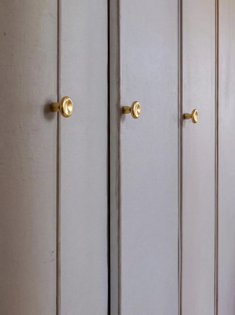 Top Shelf Unlacquered Brass Cabinet Knobs Straight Up Modern Round Dish Hardware Featuring Live Patina Finish 1.18 Inch Face Width For A Cool Kitchen Revamp Two Pack Bundle on white cabinets.