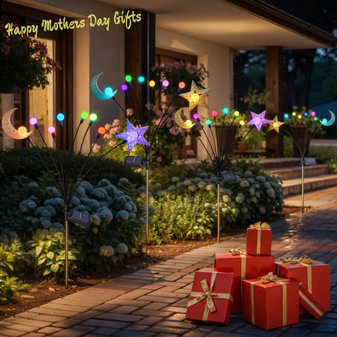 Decorative pathway with crescent moon and star lights, garden landscape, blooming flowers, and red gift boxes on paved path
