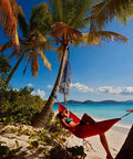 Person relaxing in Lightweight One Person Portable Hammock For Camping Hiking Backpacking Travel Festivals And The Beach on sandy beach