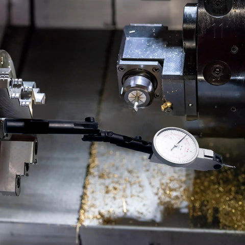 Dial indicator holder with adjustable 3-pivot axial arm and dial gauge mounted on a metal lathe.