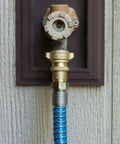 Camco brass marine/RV water pressure regulator, 40-50 PSI, attached to blue braided hose.