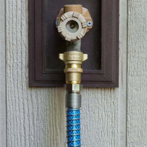 Camco brass marine/RV water pressure regulator, 40-50 PSI, attached to blue braided hose.
