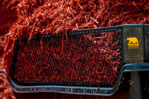 Close-up of Heavy-Duty ATV UTV Utility Trailer with 1500 lb capacity loaded with mulch, highlighting the rugged and rustproof poly tub.