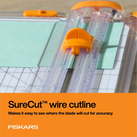 Precision Paper Trimmer With SureCut Wire Cut Line And TripleTrack System cutting green paper, clear rail for accuracy.