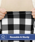 Hands stretching a black and white buffalo plaid waterproof elastic fitted 6ft picnic table cloth 2 pack, 30x72 inches, reusable.