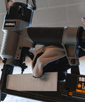 Close-up of 3 In 1 Pneumatic Nail Gun That Rocks A 16 GA Finish Nailer 18 GA Brad Nailer And Stapler in use with staples.