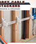 200 Piece Cable Management Kit With Steel Nails And White Wire Clips. Grey cable stackers holding wires on wooden wall.