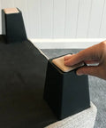 No Sweat Top Tier 2 Inch Square Furniture Sliders With Self Adhesive Backing on furniture leg, showing beige glides for easy movement.