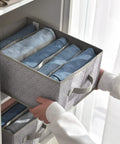 Person holding Five Grid Wardrobe Organizer For Folded Clothes And Jeans Stackable Closet Drawer Storage In Gray from shelf