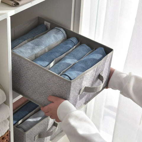 Person holding Five Grid Wardrobe Organizer For Folded Clothes And Jeans Stackable Closet Drawer Storage In Gray from shelf