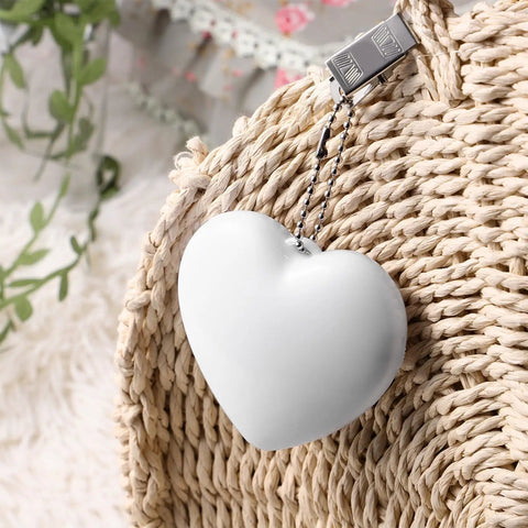 Two Pack Heart Shape Purse Lights With Sensor Illuminator For Handbags hanging on a woven bag