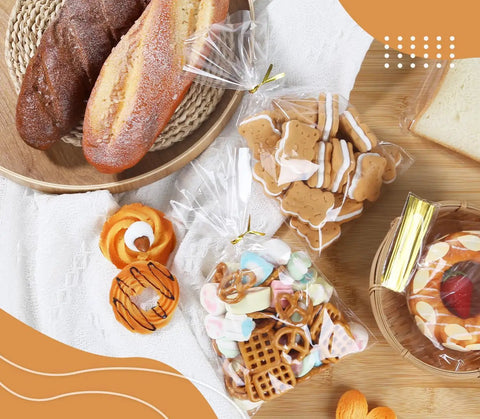 Clear Cellophane Treat Bags 200 Pack 6X10 Inch With Gold Twist Ties For Cookies Candy Birthday Party Favors Graduation And Homemade Bakery Packaging Must Have Bulk Value Pack Food Grade Small Candy Bags filled with candy and cookies.