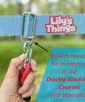 Hand holding carabiner and slackline setup for 2 Pack Monkey Bars For Backyard Playset With Ninja Slackline Attachments For Slackline Obstacle Course And Home Playground Equipment Sets Durable Weatherproof Build For Year Round Outdoor Fun Kid Approved.