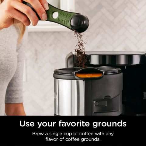 Person scooping coffee grounds into a Hot And Cold Brew System With Thermal Carafe All In One Coffee And Tea Maker, BPA Free.