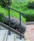 Built Like A Brick Carbon Steel Handrail For Outdoor Steps Rust Free Wrought Iron Style Stair Railing with heavy duty brackets installed on steps.