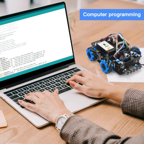 Arduino-compatible robot car kit with blue mecanum wheels and exposed wiring, shown beside a laptop.