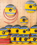 Spools of 3 To 1 Heat Shrink Tubing With Adhesive Lined Marine Grade Black 65 Ft Roll, one quarter inch diameter on a pegboard display.