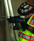 Worker using Dust Collection Attachment for SDS Max Hammer Drill with dual air chambers, vacuum nozzle fits 1-3/8 inch.