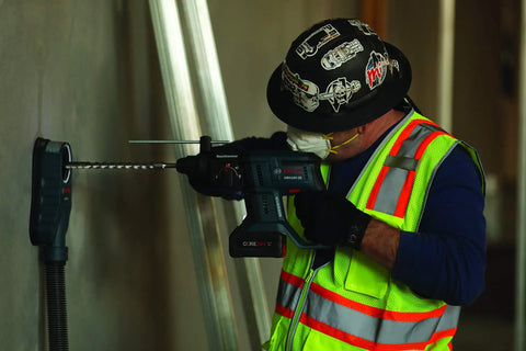 Worker using Dust Collection Attachment for SDS Max Hammer Drill with dual air chambers, vacuum nozzle fits 1-3/8 inch.