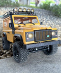 One Twelfth RC Crawler MN98 Remote Control Truck Off Road Four By Four Land Rover Defender Style front view on rocky terrain
