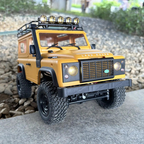 One Twelfth RC Crawler MN98 Remote Control Truck Off Road Four By Four Land Rover Defender Style front view on rocky terrain